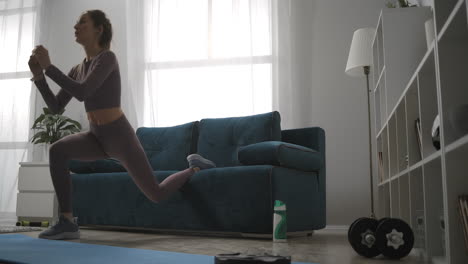 young-woman-is-using-couch-like-sport-equipment-during-home-training-at-weekend-doing-crouching-in-living-room-healthy-and-sporty-lifestyle-at-self-isolation